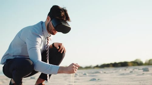 Man Experiencing Virtual Reality on Sandy Beach