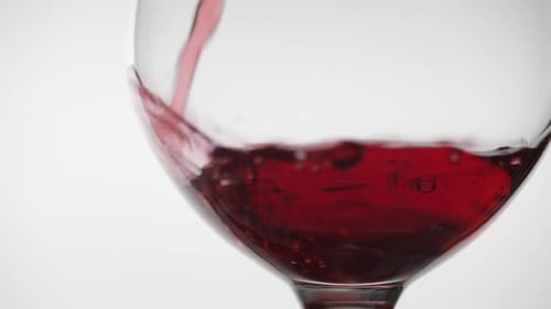 Rose Wine. Red Wine Pour in Wine Glass Over White Background. Slow Motion