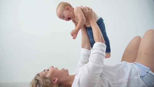 Happy Mother Lifting Baby Upward