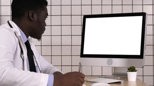 Young African Doctor in A Lab Coat Sitting in His Office