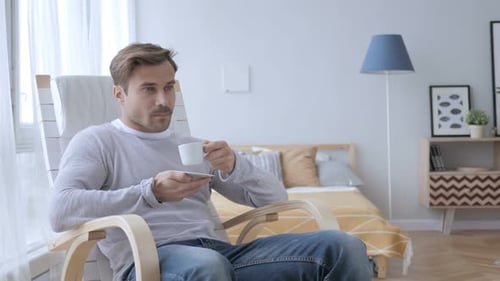 Man Drinking Coffee in Modern Chair