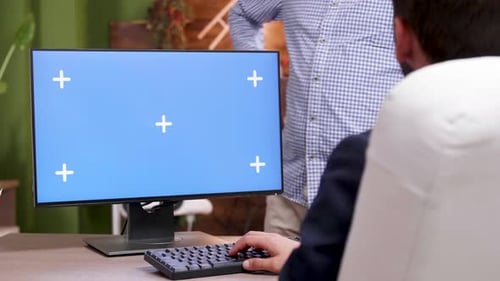 Businessman Typing on Computer with Green Screen in His Office