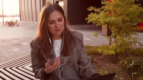 Young Woman Working On Laptop Outdoors at Sunset