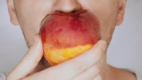 Close Up Face Fair Man Eats Red Peach