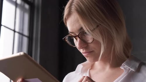 Woman Uses Tablet Indoors, Close Up
