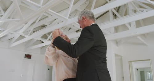 Elegant Adult Couple Dancing in Bright Room