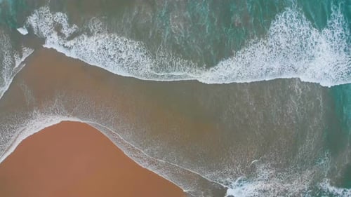 Aerial View of Sea Waves Break on Yellow Sand Beach