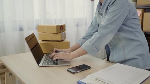 Enthusiastic Woman Celebrating Success with Laptop and Boxes