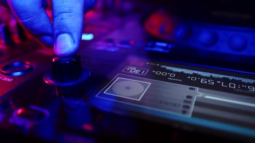 DJ Hand Adjusts Knob on Turntable in Club