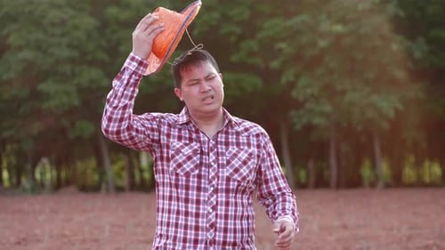Asiatischer Bauer wird müde von der Arbeit auf dem Bauernhof