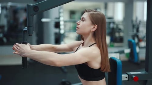 Woman Using Exercise Machine at the Gym