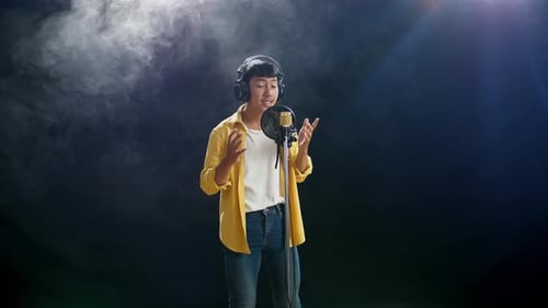 Young Adult Sings into Microphone in Studio