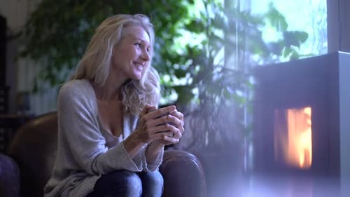 Woman Enjoying Coffee by Fireplace