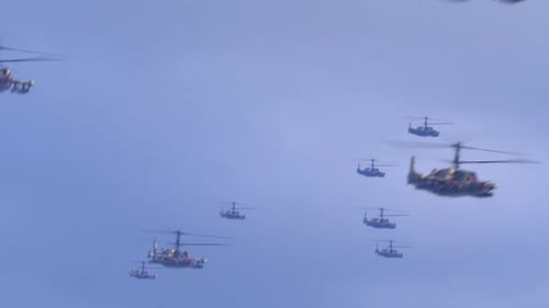 a large number of helicopters flying against the blue sky