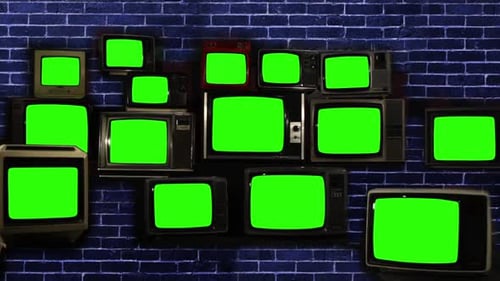 Stack of Retro Vintage TV Turning On Green Screens over Blue Brick Wall. Zoom In.
