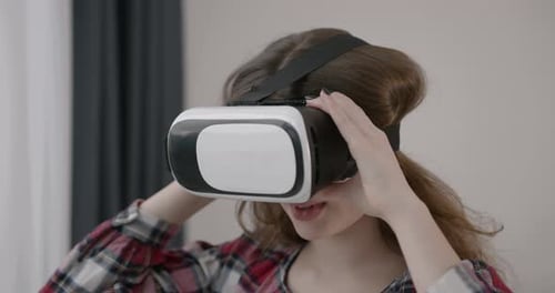 Woman Puts on Virtual Reality Headset in Home