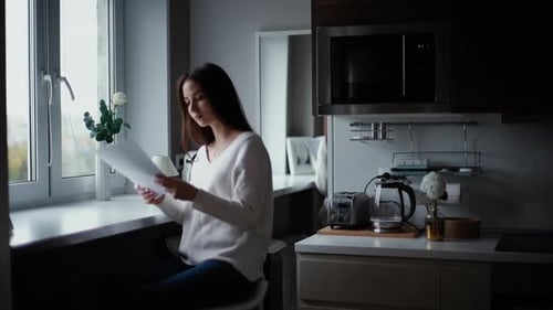 Woman Reviews Documents with Man in Kitchen