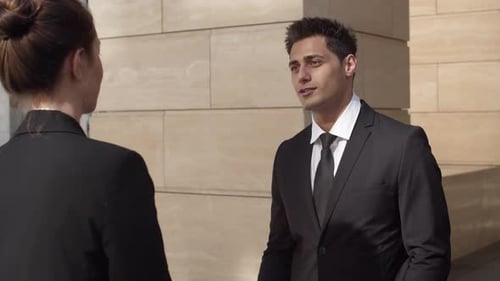 Businessman Talking with Colleague Outside Office Building