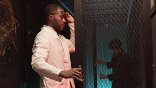 Man Opens Server Rack in Data Center