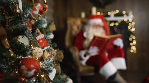 Papá Noel borroso sostiene un viejo álbum de seda roja cerca del árbol de Navidad con juguetes y luces