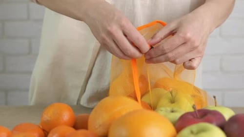 Mujer pone frutas en bolsas reutilizables