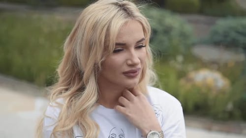 Woman with Wavy Blonde Hair Poses Outdoors
