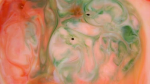 Footage. Ink in Water. Red and Orange Ink Reacting in Water Creating Abstract Background