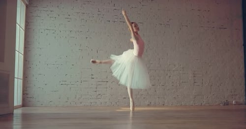 Young Professional Ballerina Lifts a Leg Back Makes a Turn of the Body