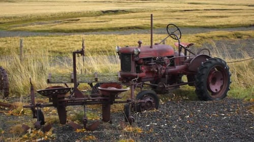 Old rusted tractor in field in slow motion