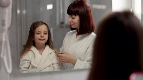 Mother Brushing Daughter's Hair in Bathroom