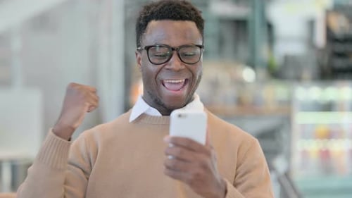 Man Celebrates While Looking at Phone, Close Up