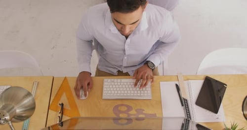 Blick von oben auf einen Mann, der im Kreativbüro arbeitet