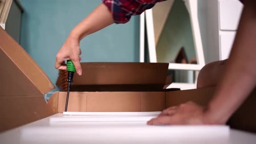 Person Assembling Furniture With Screwdriver Close Up