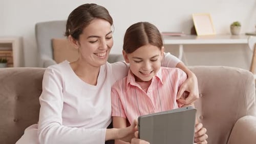 Woman and Child using Tablet Indoors at Home