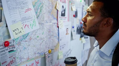 Investigator Analyzes Evidence Board with Photos and Maps