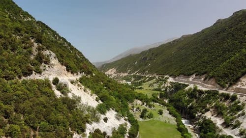 Aerial Drone Footage View Flight Over Mountain with Forests Fields and River in Sunrise Soft Light