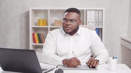 Workplace of freelance worker at home office. Young African-American man.