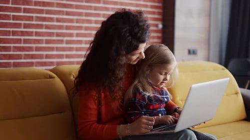Woman and Child Using Laptop Together at Home