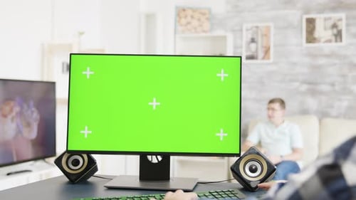 Mann arbeitet auf Greenscreen-PC-Display in heller und moderner Wohnung