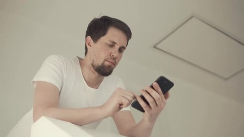 Man with Cell Phone Staying Home.