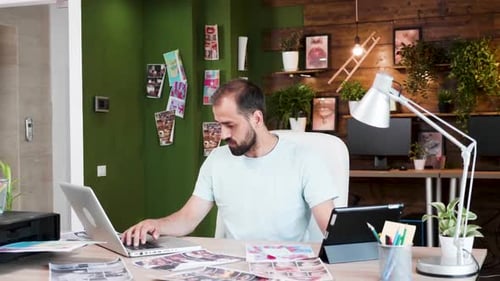 Man Works on Laptop in a Modern Office