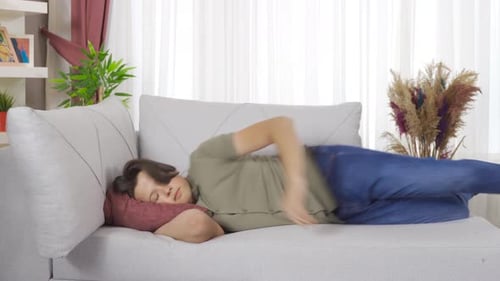 Young Adult Lying Down to Sleep on Couch