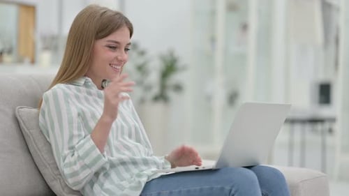Woman Smiling, Video Chatting on Laptop at Home