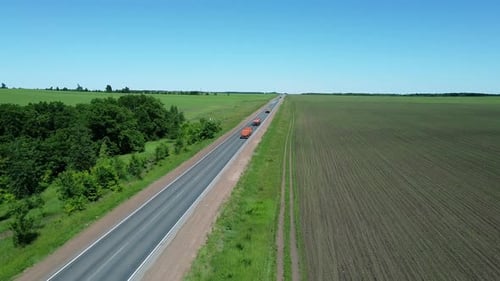 Aerial view of a highway traffic. Trucks transport goods. Scenic view of road going to the horizon