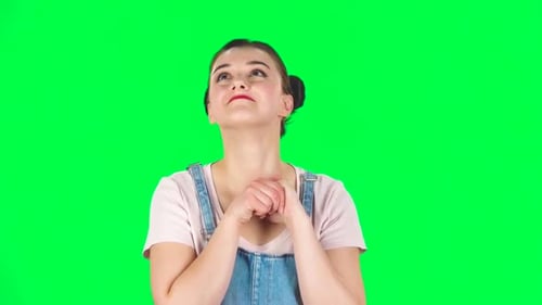 Lovely Girl Daydreaming and Smiling Looking Up Against Green Screen, Slow Motion