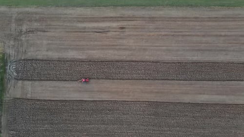 Aerial View of Agricultural Field Modern Red Tractor Plowing Land.