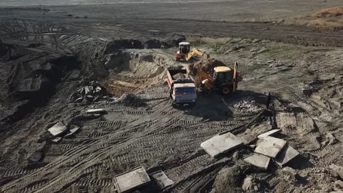 Bulldozers Loading Dirt into Dump Truck on Site