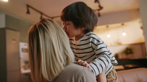 Glücklicher kleiner asiatischer süßer Junge, der sich umarmt, umarmt ihre Mutter und genießt es