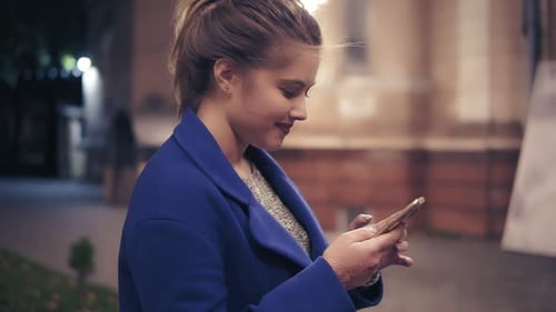 Beautiful Young Woman Using Her Smart Phone Late at Night in the City