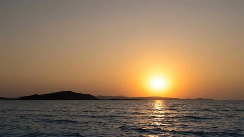 Zeitraffer des wunderschönen Sonnenuntergangs über dem Meereshorizont mit leuchtend orangefarbenen Farben und Meereswellen